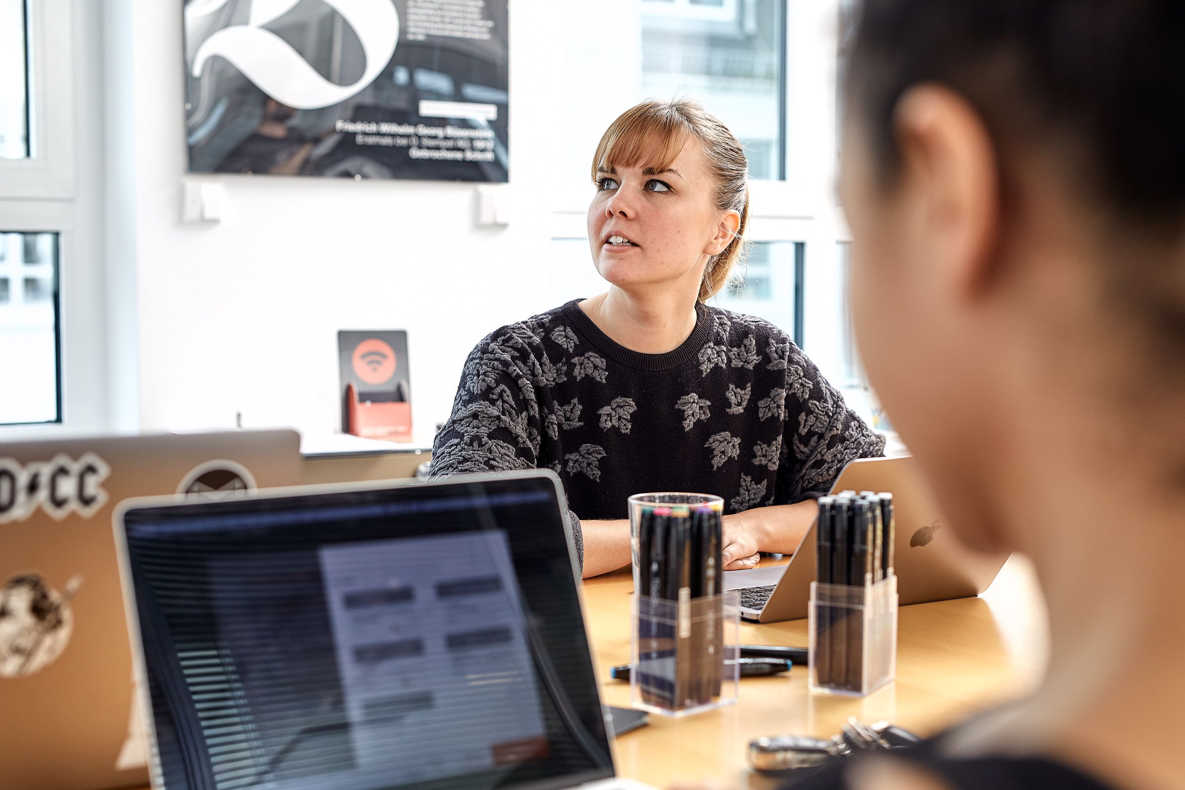 Woman thinking about User Experience in meeting